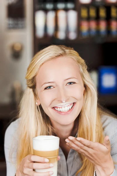 Uśmiechający się z pianką mleka na jej twarzy — Zdjęcie stockowe