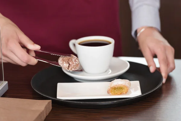 Cameriera che serve cibo dolce con caffè a tavola — Foto Stock