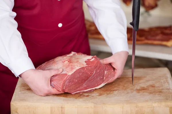 Carnicero sosteniendo carne en la tienda —  Fotos de Stock