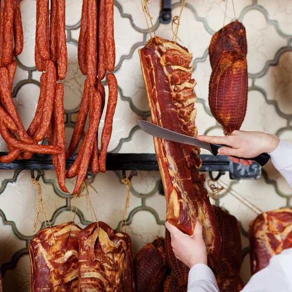Slagerij handen snijden van vlees met mes In winkel — Stockfoto