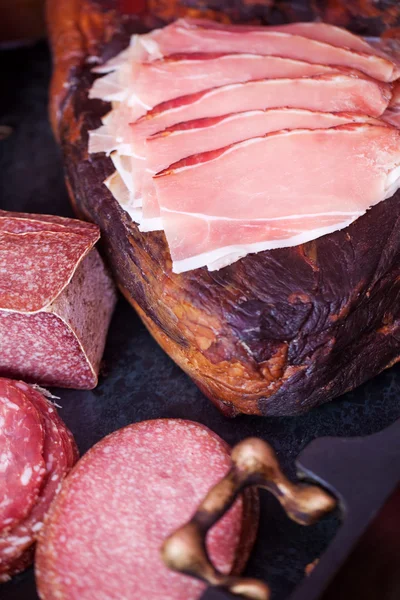 Variedad de jamón que se exhibe en la tienda — Foto de Stock