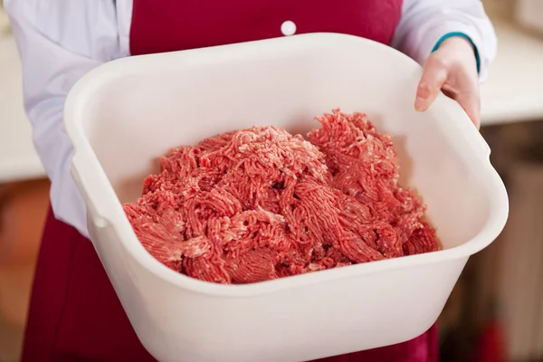 Slager houden gehakt vlees container in winkel — Stockfoto