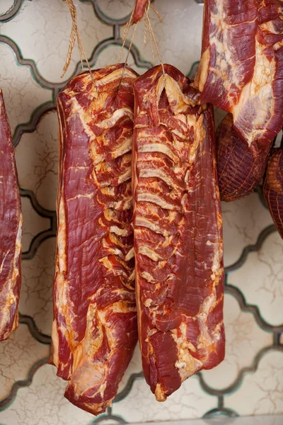 Morceaux de viande accrochés dans la boutique — Photo