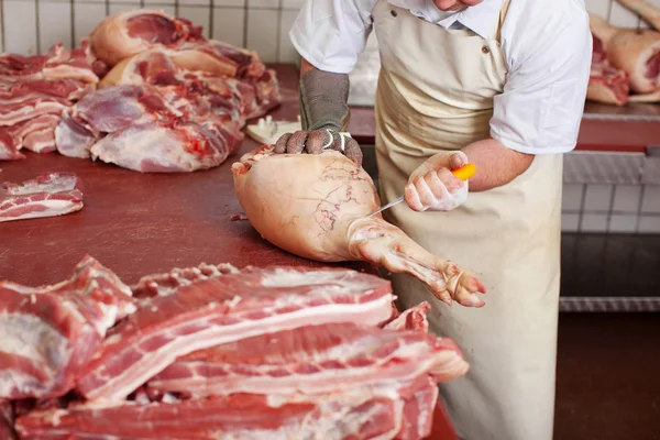 Macellaio che taglia carne di maiale con coltello in negozio — Foto Stock