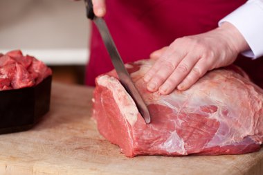 Butcher cutting raw meat clipart