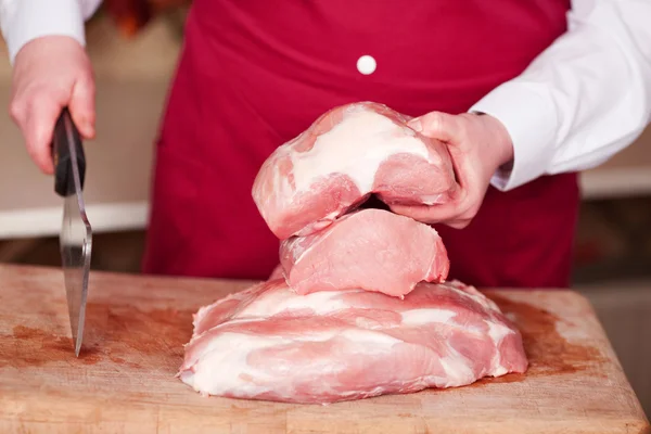 Saleswoman holding knife and a piece of meat — Stock Photo, Image