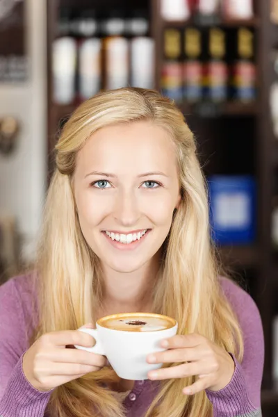 Pretty woman holding cup of cappuccino — Stock Photo, Image