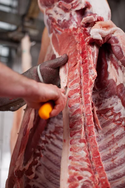 Mãos de açougueiro cortando carne na loja — Fotografia de Stock