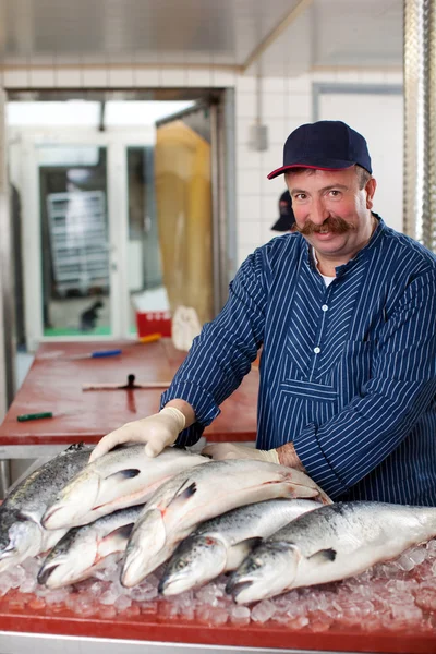 Hombre vendiendo salmón en el mercado de pescado —  Fotos de Stock