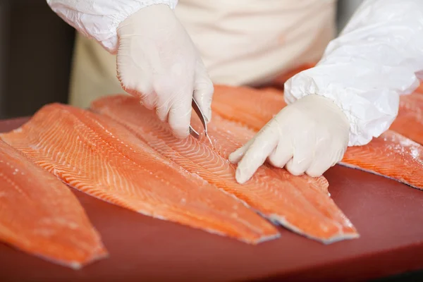 Worker deboning salmon — Stock Photo, Image