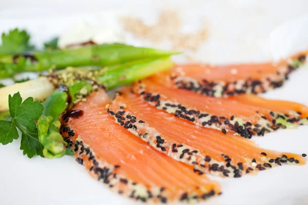 Fette di salmone con semi di sesamo e wasabi in piatto — Foto Stock