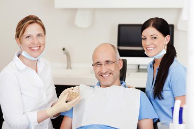 Dentist With Teeth Model And Male Patient clipart
