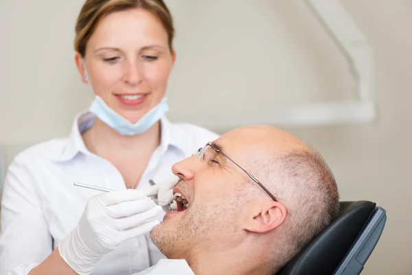 Dentista femminile che esamina i pazienti di sesso maschile bocca — Foto Stock