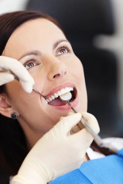 Mani del dentista esaminando paziente femminile alla clinica — Foto Stock