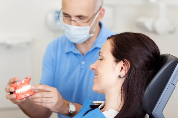 Dentista maschio spiegando denti artificiali — Foto Stock