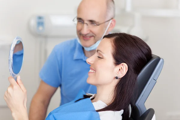 Patiënt met arts kijken naar spiegel in kliniek — Stockfoto