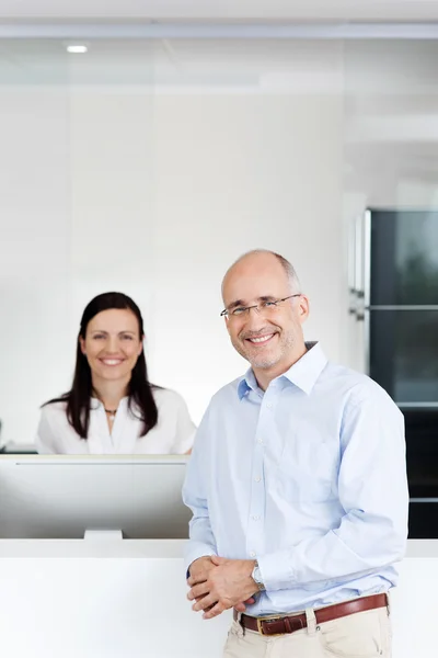 Happy Patient And Receptionist At Reception — Stock Photo, Image