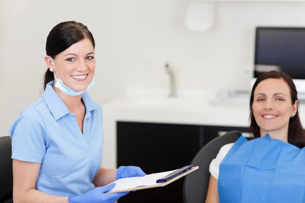 Giovane assistente dentista sorridente e paziente — Foto Stock