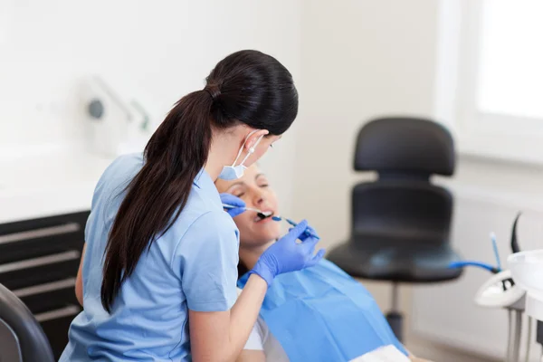 Jovem dentista Assistente Examinando pacientes Boca — Fotografia de Stock