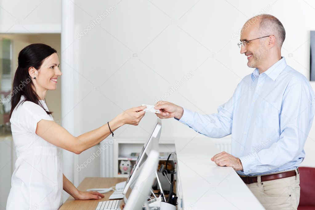 Receptionist Receiving Card From Patient In Dentist Clinic — Stock
