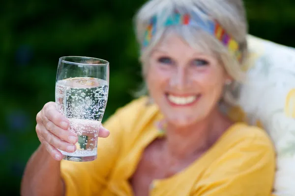 Dame âgée buvant de l'eau pétillante — Photo