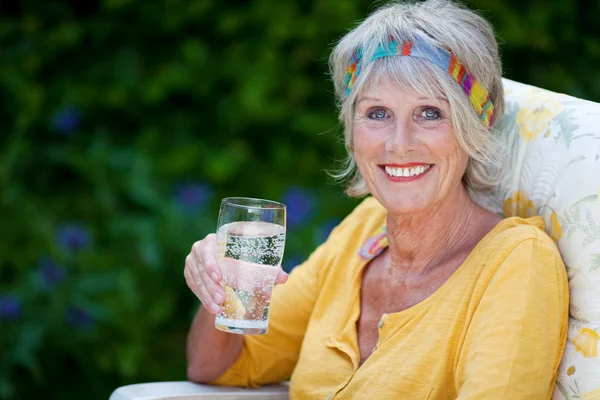 Elderly lady holding a glass of water — Stock Photo, Image