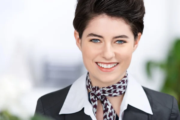 Уверенная молодая предпринимательница улыбается в офисе — стоковое фото