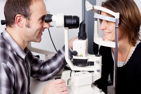 Opticien examiner les yeux des patients — Photo