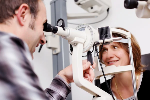 Oudere opticien testen van patiënt ogen In onderzoek kamer — Stockfoto