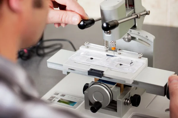 Optiker bohrt randlose Brillen in Werkstatt — Stockfoto