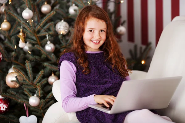 Menina relaxante na frente de uma árvore de Natal — Fotografia de Stock