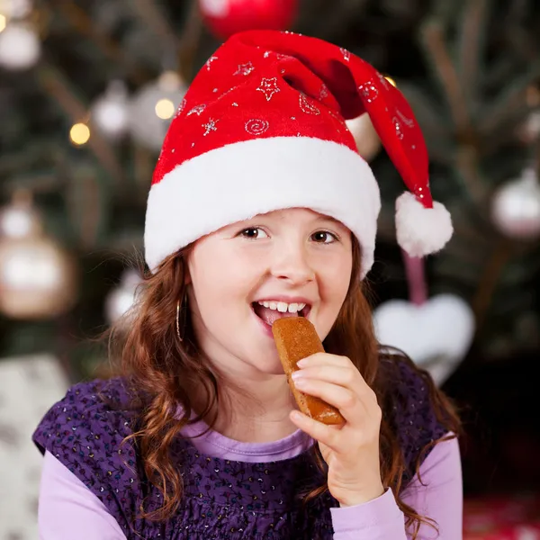 Little girl eating Christmas candy — Stock Photo, Image