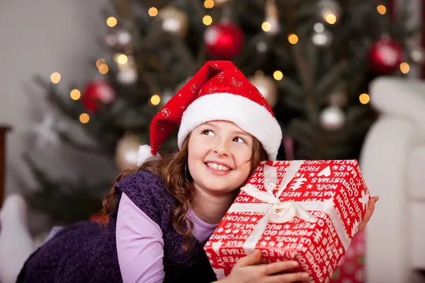 Kleines Mädchen mit ihrem Weihnachtsgeschenk — Stockfoto