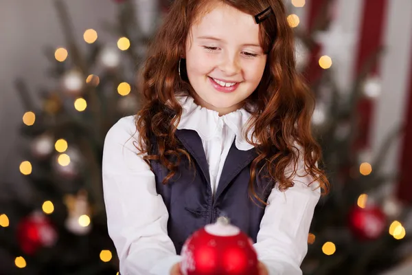 Chica sonriente con una bola de Navidad — Foto de Stock