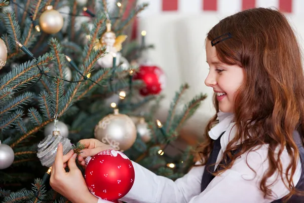 Gelukkig meisje opknoping van de kerstballen — Stockfoto