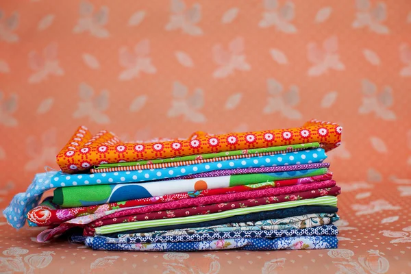 Various Stacked Clothes On Sofa At Workshop — Stock Photo, Image