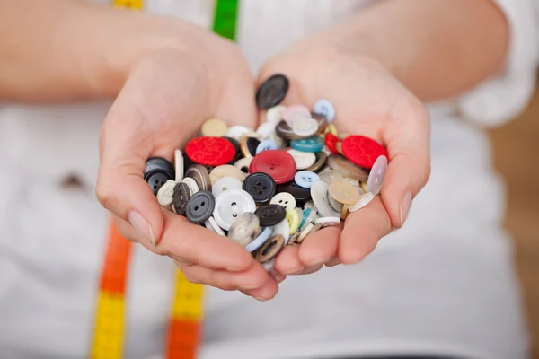 Frau zeigt eine Sammlung von Knöpfen — Stockfoto