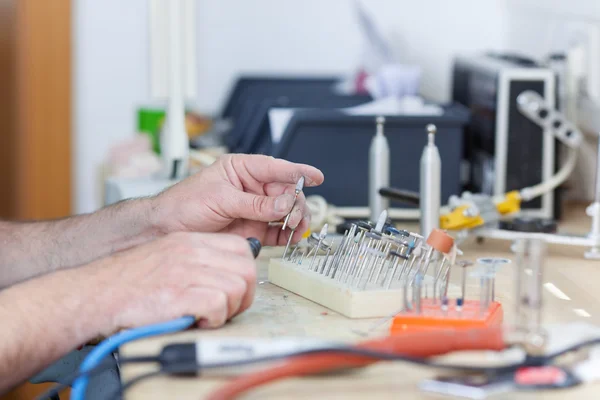 Técnico dentário com broca em laboratório — Fotografia de Stock