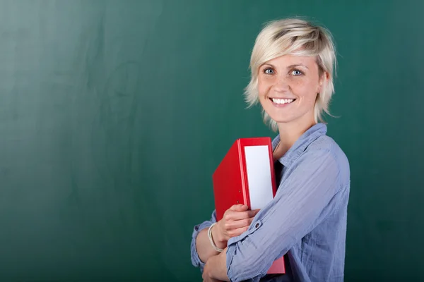 Young student standing and holding a folder — Stock Photo, Image