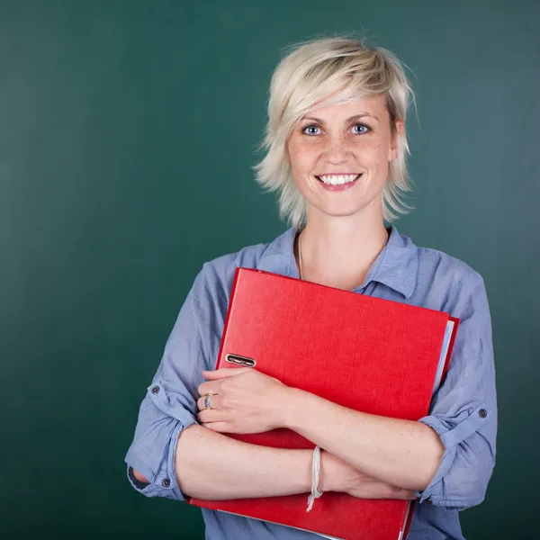 Mulher com pasta na frente de Chalkboard — Fotografia de Stock