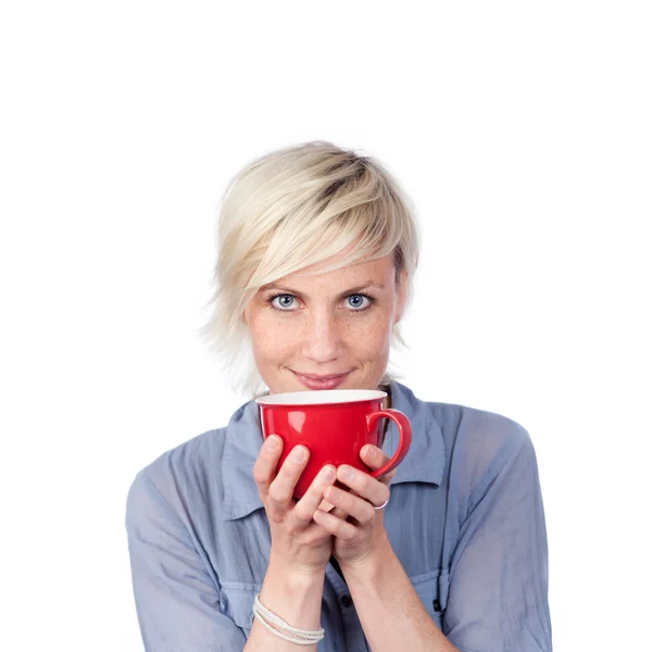 Mujer rubia joven sosteniendo la taza de café rojo — Foto de Stock