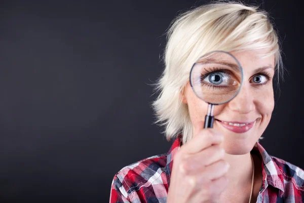 Närbild av blond kvinna med förstoringsglas — Stockfoto