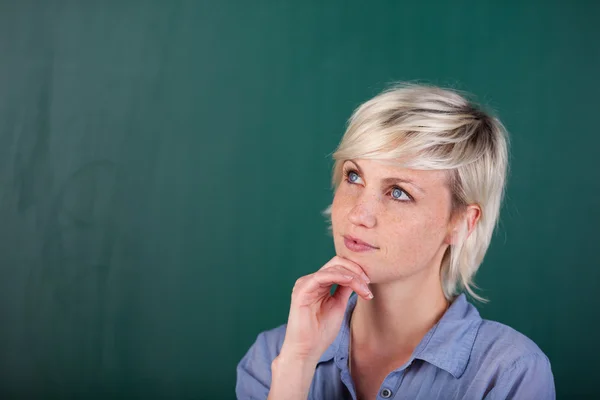 Young woman standing in front of the blackboard — Stock Photo, Image