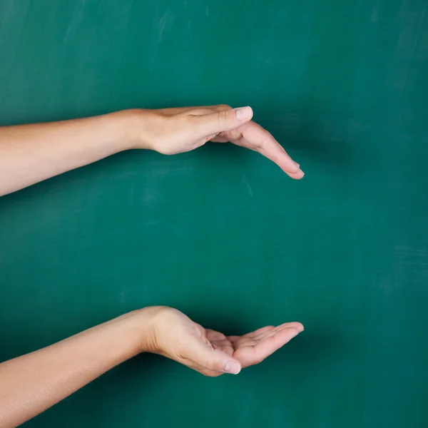 Mani di donna vuota a coppa contro tavola verde — Foto Stock