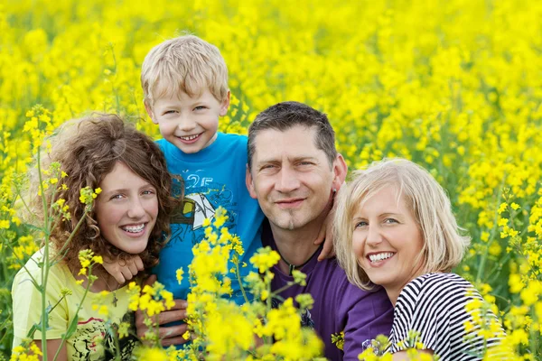 Familia sonriente entre flores de violación —  Fotos de Stock