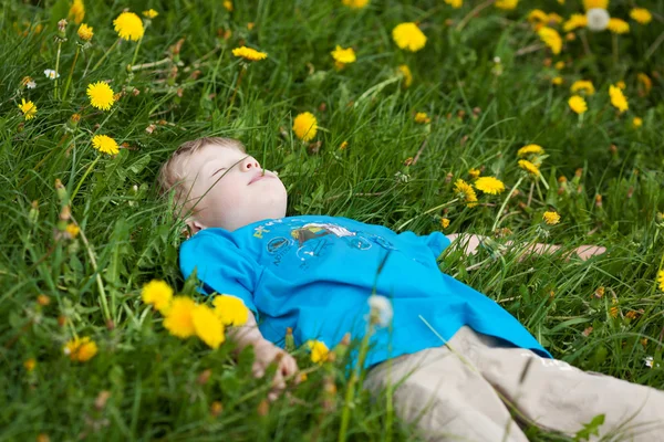 Petit garçon dormant sur l'herbe verte — Photo