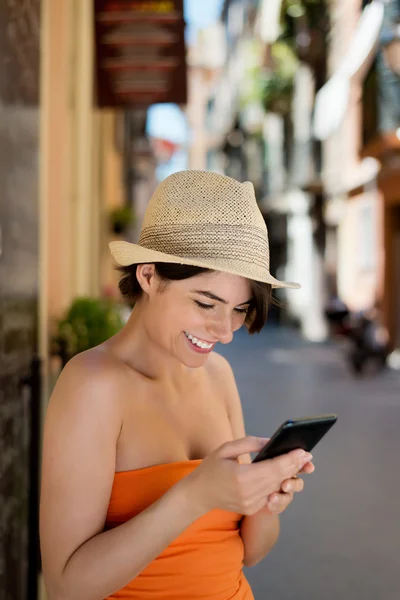 彼女の携帯電話に sms を読んで笑顔の女性 — ストック写真