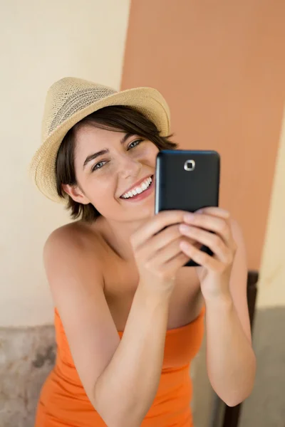 Riendo joven mujer fotografiándose a sí misma —  Fotos de Stock