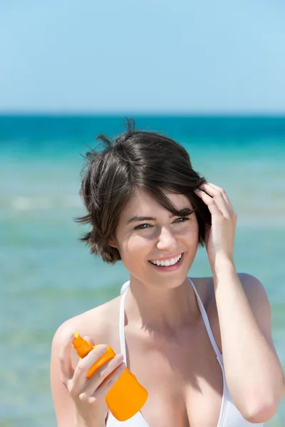 Frau mit Sonnencreme am Meer — Stockfoto