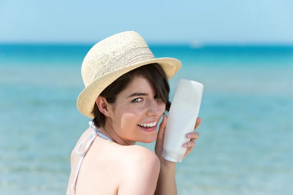 日焼け止めクリームのボトルとささいな女性 — ストック写真